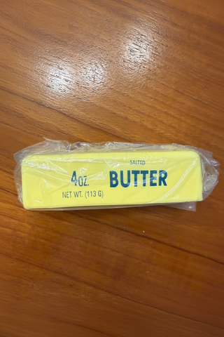 Packaged 4 oz. butter bar on a wooden surface