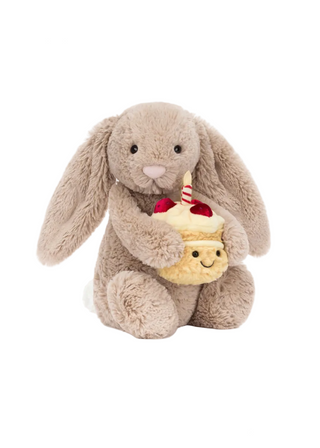 Plush toy bunny holding a birthday cake