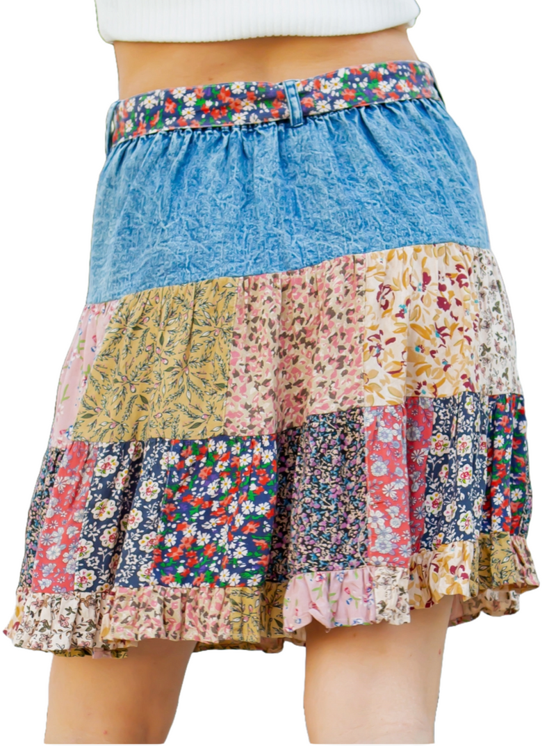 Bohemian Gypsy Mini Skirt  Picture strolling through a buzzing urban street fair, radiating trendy vibes in your denim mini skirt adorned with rayon print patch tiers. The skirt's top boasts two chic pockets and a matching tie-around belt, evoking a bohemian spirit. You effortlessly blend style and individuality in this fashion-forward ensemble, turning heads at every turn.  Material:  Rayon back