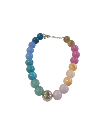 Colorful beaded necklace on a white surface with a blurred background