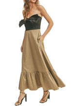 This strapless half-black, half-brown dress with a dimensional bow across the chest and a ruffle on the bottom is a fashion-forward and elegant choice. Its creative design elements, color contrast, and attention to detail make it a standout dress for those who want to make a sophisticated yet artistic statement at any event.