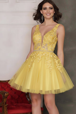 Woman wearing a yellow dress with yellow lace details, standing in front of a red chair and gray wall.