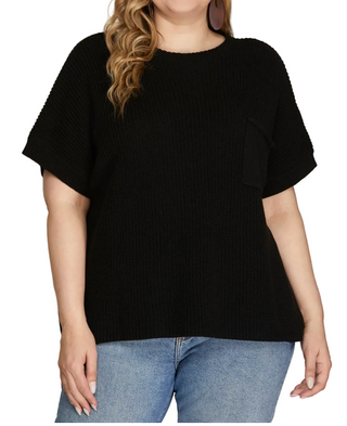 Person wearing a black sweater and blue jeans on a gray background