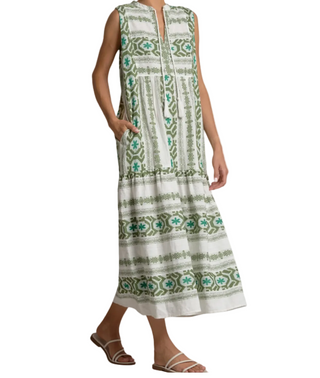 A sleeveless midi dress with a green and teal geometric pattern on an off-white base, featuring a split neckline and side pockets, shown on a model against a white background.