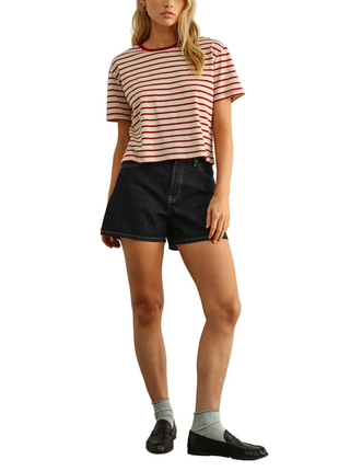 Person wearing a striped shirt and black shorts against a plain background