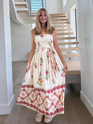 Woman in a floral dress standing in a modern home interior.