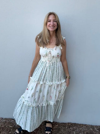 Woman wearing a white floral dress against a plain background