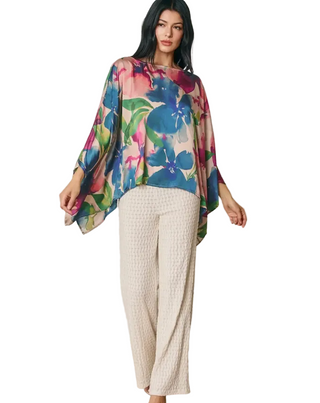 a woman wearing a jewel tone Floral Satin Poncho Blouse