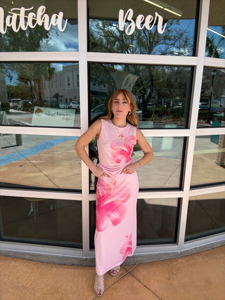 Person wearing a pink floral dress leaning against a glass door with 'Beer' and 'Lofthouse' signs.