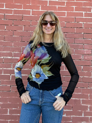 a woman wearing a black Free People Lilly Printed Longsleeve Top Black Combo