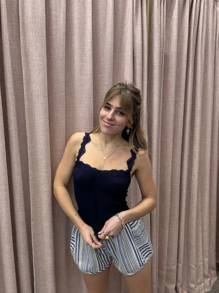 Woman lying on a large inflatable mattress with pleated curtains in the background