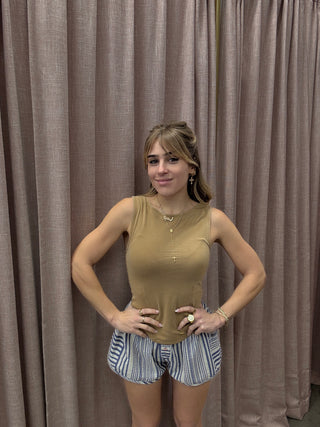 Woman lying on a brown inflatable mattress with a striped pillow