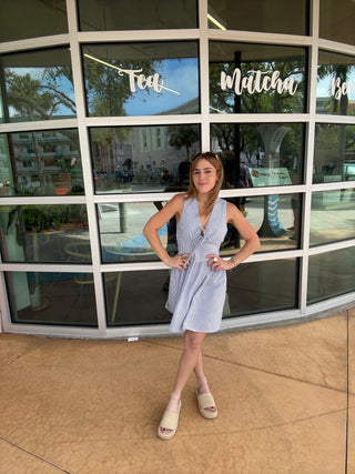 Person posing in front of a glass door with reflections
