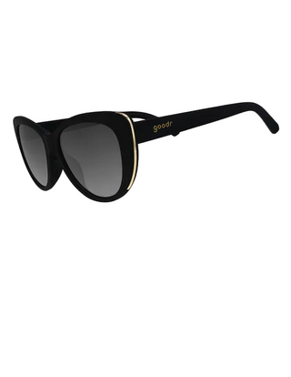 Black cat-eye sunglasses with gray gradient lenses and a gold accent stripe on the frame, featuring the 'goodr' brand name on the temple arm.