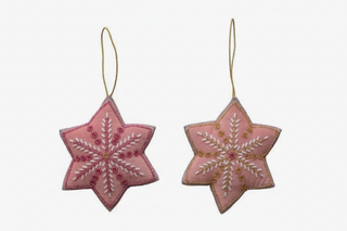 Two pink embroidered star-shaped hanging ornaments with gold loops, shown on a plain light background. One ornament has white embroidery and the other has gold embroidery, with the text 'Lula Bell Whimsical Cards and Gifts' visible at the bottom.