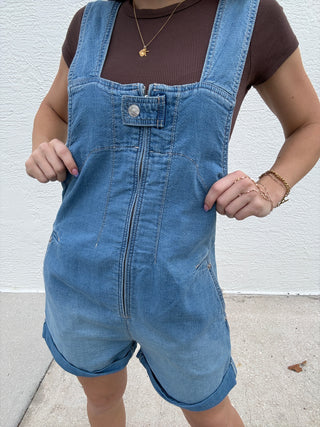 Person wearing a blue denim dress with a white background