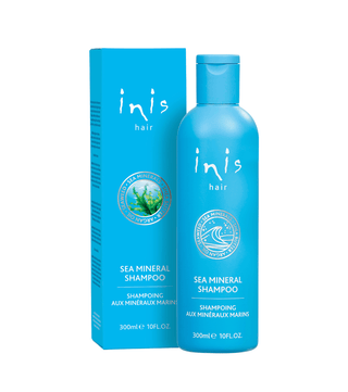 Blue shampoo bottle and packaging with 'inis hair' branding on a white background