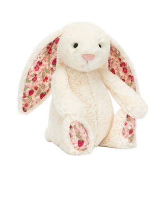 A plush bunny stuffed animal in cream-colored fur with long ears and pink floral lining, shown on a white background with product text below reading 'Blossom Cream Bunny 'Berry' and a price of $33.00 USD.