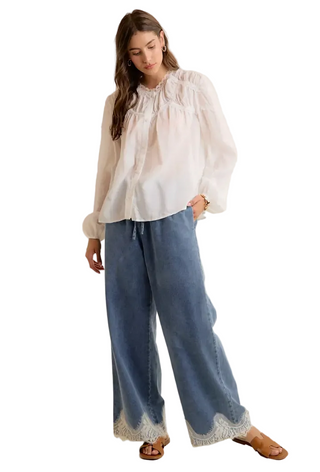 a woman wearing Lace-Trim Denim Pants medium wash denim pants.