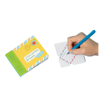A hand holding a blue pen writes on small white letter cards next to a yellow and green box labeled 'Little Letters for Lunch' on a bright blue background.