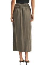 The distinctive feature of this skirt is the row of buttons down the middle. Whether you're heading to a picnic, a day at the office, or a casual gathering with friends, this skirt strikes the right balance between comfort and style. Its mossy green color adds a touch of freshness and nature-inspired charm to your outfit. The skirt features a comfortable elastic waistband, ensuring a secure and flexible fit.(back)