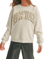 New York Boucle Letter Sweat Shirt  Check out this crew neck sweatshirt – it's like a warm, cuddly hug from the city that never sleeps! The New York letters are all fuzzy and boucle, giving you that extra touch of snuggly glam. It's like wearing a piece of the Big Apple's sparkle on your chest, perfect for cozy adventures in the concrete jungle or just chillin' with some 'hood vibes  Material:  50% Cotton 50% Polyester
