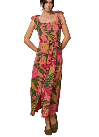 Woman wearing a pink floral dress against a beige wall