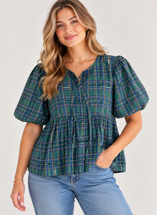 woman in a blue and green plaid shirt and jeans