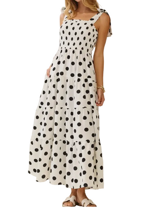Woman wearing a polka dot dress against a plain background