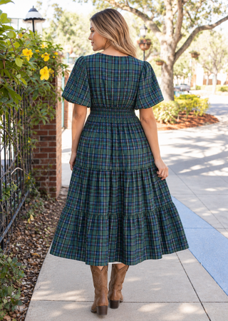back view of woman in a midi dress in green and blue plaid