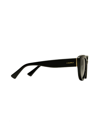 Black sunglasses with gold accents on a light gray background