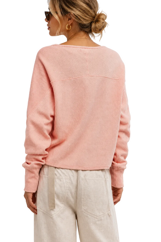 Person wearing a pink sweater on a white background