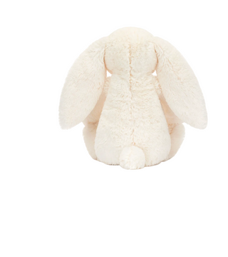 A cream-colored plush bunny toy shown from the back, featuring long floppy ears and a soft, textured fur surface, isolated on a solid white background.