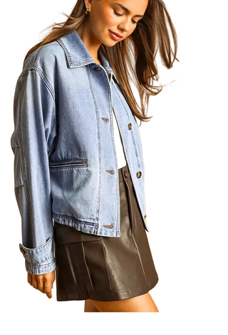 A woman wearing a light-wash blue denim jacket over a white top and a dark brown faux-leather mini skirt, posed against a warm tan studio background. Small thumbnail previews of the jacket design appear along the bottom edge.