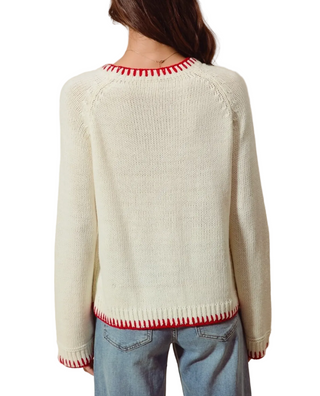 A woman wearing a cream Merry Christmas Sweater