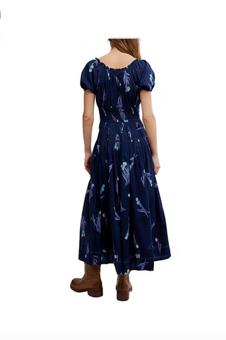 Navy blue dress with white patterns worn by a person on a white background