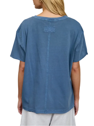 Person wearing a blue t-shirt in a laundry room.