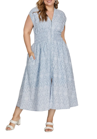 Woman wearing a blue patterned dress on a gray background