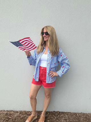 Woman holding an American flag against a plain background