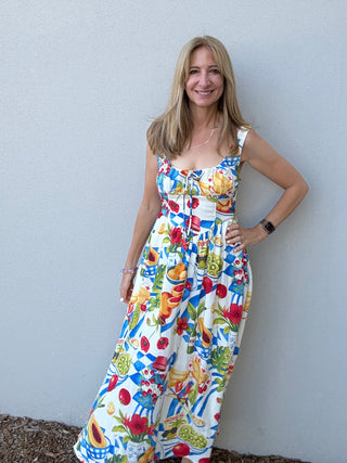 Woman wearing a colorful floral dress against a plain background