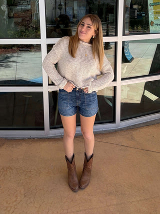 Person standing in front of a large glass window with reflections.