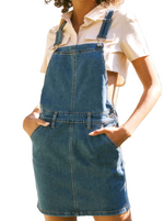 Vivi Mini Skirt Overalls  Our Vivi Mini Skirt Overalls feature a rich blue tone with contrast stitching that gives this piece a stylistic edge. Sits slightly above the natural waistline as it relaxes down the hips creating a casual fit that's fun and flirty. Made with comfort-stretch denim that's soft and durable giving you a flexible fit every time. Features a four-pocket design, triple-button side closure, front bib, and clasped straps on both shoulders. 