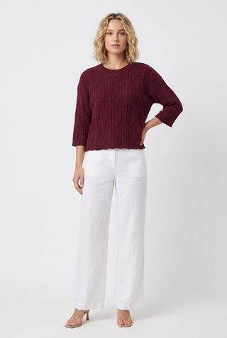 a woman wearing a Wine Cable Sweater
