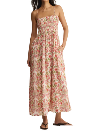 Woman wearing a floral dress against a plain background