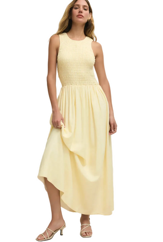 Woman wearing a light yellow dress against a plain background