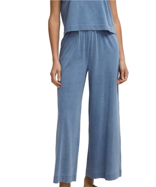 Person wearing blue pants on a plain background