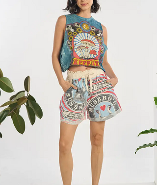 Person wearing a colorful sleeveless top and shorts with graphic designs on a white background