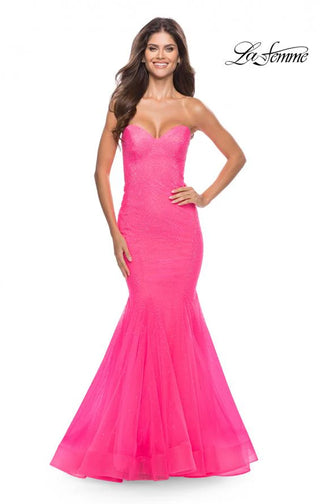 Woman wearing a pink evening gown with 'La Femme' branding on a white background