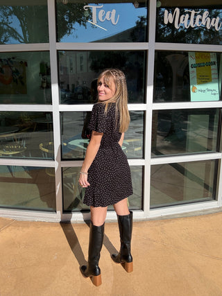 woman in a polka dot black and white wrap dress short back