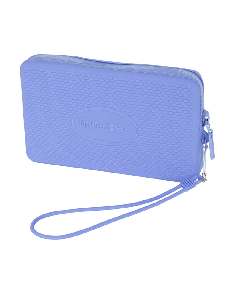 Provence Blue Mini Bag Logo  Hit the beach or the town with your essentials stowed safely in the stylish Minibag Logo. Featuring our signature rice pattern in chic colors and finished with a Havaianas logo. Your phone — even the big ones! — ID, credit cards, and a lip gloss or two stay secure and protected thanks to a zipper closure and water and sand-resistant construction. A sleek wrist strap lets you carry it all in comfort.  Brand: Havaianas Material: 100% Silicon Size & Fit: 7" by 4"  